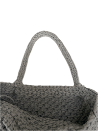 a grey knitted tote bag on a black background