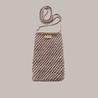 a small knitted bag with a handle on a grey background