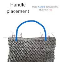 a crocheted bag with a handle placed on it