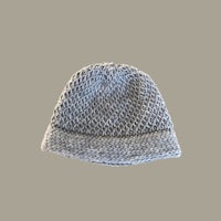 a grey knitted hat on a beige background