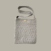 a grey crocheted bag on a beige background