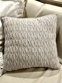 a knitted pillow on a couch