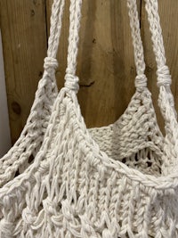 a white crocheted bag on a wooden table