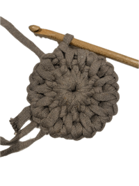 a crocheted circle with a knitting needle and a crochet hook