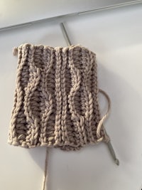 a knitted square with a crochet hook on it