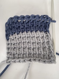 a grey and blue crochet stitch with a crochet hook