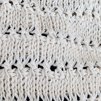 a close up of a white knitted blanket