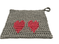 a crochet pot holder with two hearts on it