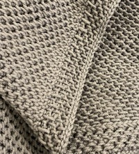 a close up of a grey knitted blanket